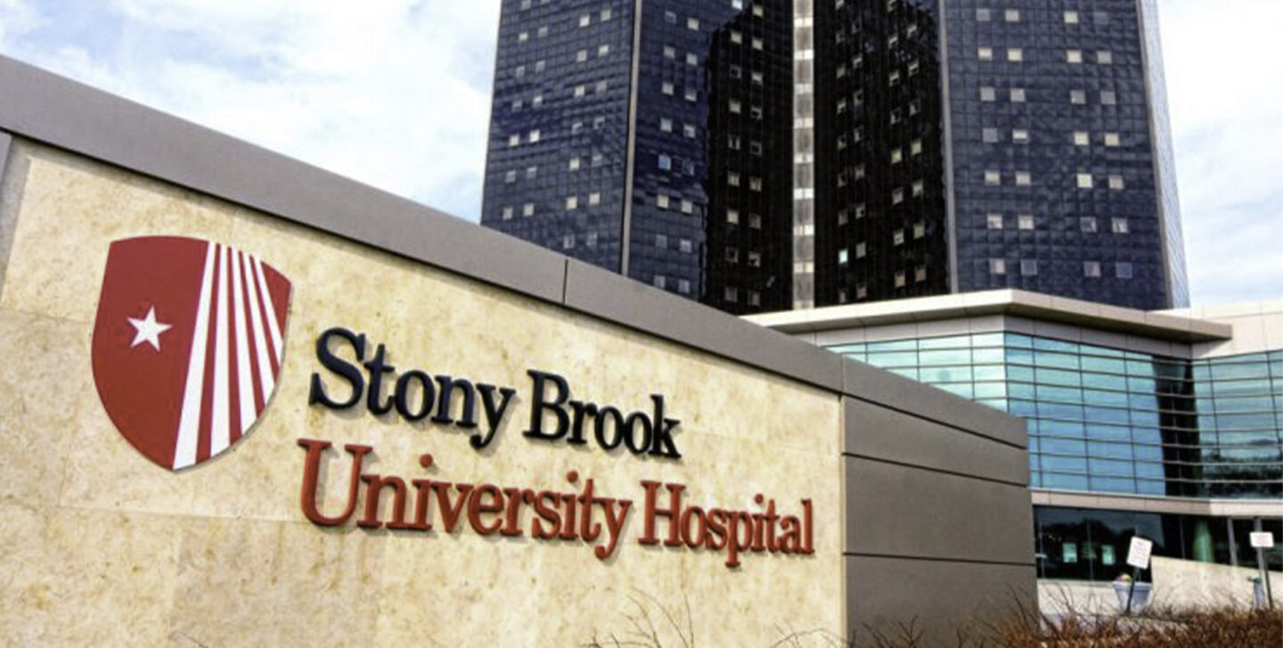 Stony Brook Hospital sign with the hospital in the background.